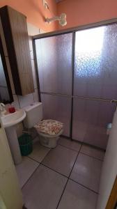a bathroom with a shower and a toilet and a sink at Pousada da Dinda - Casa Familiar in São Gabriel +6 photos