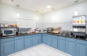 eine Küche mit blauen Schränken und einer Arbeitsplatte in der Unterkunft The Windstar Hotel - Emerald Isle, Swansboro in Cedar Point