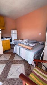 ein Hotelzimmer mit 2 Betten und einem Kühlschrank in der Unterkunft Pousada da Dinda - Casa Familiar in São Gabriel