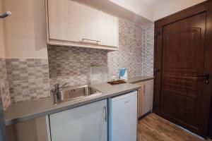 een keuken met een wastafel en een houten deur bij PORTO TIMONI in Afionas