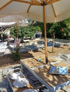 een picknicktafel met een parasol op een patio bij Bella Terra Nature Living in Asprovalta