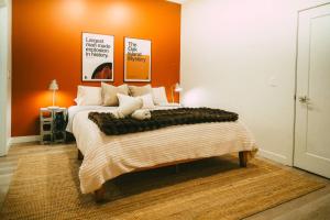 a bedroom with a large bed with an orange wall at Historic Charming 2BR Apartment DT Halifax in Halifax