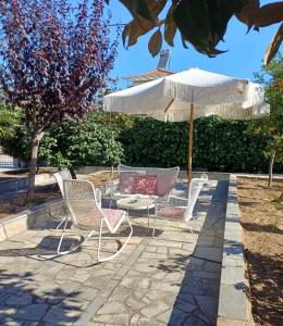 een groep stoelen en een tafel en een paraplu bij Bella Terra Nature Living in Asprovalta