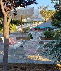 een groep stoelen en een parasol op een patio bij Bella Terra Nature Living in Asprovalta