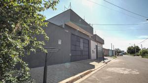 een gebouw met een grote deur aan de straatkant bij Casa com Piscina, Wi-Fi e Garagem in Pirassununga