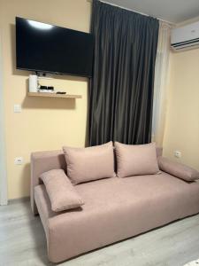 un canapé avec trois oreillers assis devant une fenêtre dans l'établissement Ema Artistic House, à Pleven