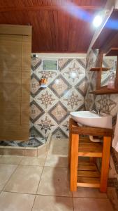 een badkamer met een wastafel en een betegelde muur bij La Tata en Yvera in San Miguel