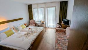 a living room with a bed and a couch at Decker's Bio Hotel zum Lamm in Baiersbronn