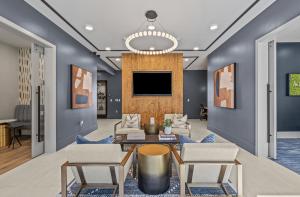 un soggiorno con pareti blu e TV di Landing Apartments - Cedar Lakes a Duncanville