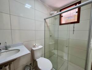 a bathroom with a toilet and a sink and a shower at Casa Vila São Miguel in Itacaré