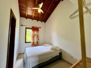 a bedroom with a bed and a ceiling fan at Casa Vila São Miguel in Itacaré