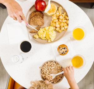 einen Tisch mit einem Frühstücksteller darauf in der Unterkunft The Windstar Hotel - Emerald Isle, Swansboro in Cedar Point