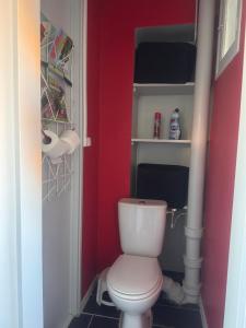 une salle de bain avec des toilettes blanches dans un mur rouge dans l'établissement Atelier Couleurs - Evreux centre, à Évreux 4 autres photos