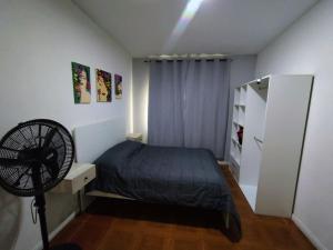 een kleine slaapkamer met een bed en een ventilator bij El descanso in Necochea