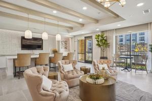 a living room with chairs and a table and a kitchen at Landing Apartments - The Quinn in Anna