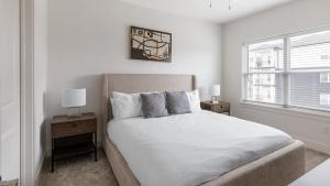 een witte slaapkamer met een bed en twee nachtkastjes bij Landing Beautiful 3BD Yoga Studio Pool in Athens +70 foto's