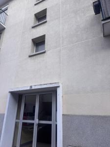 - un bâtiment blanc avec une porte et des fenêtres dans l'établissement Atelier Couleurs - Evreux centre, à Évreux