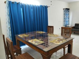 a dining room with a table and a blue curtain at Elegant Stay at Bangalore International Airport in Bangalore