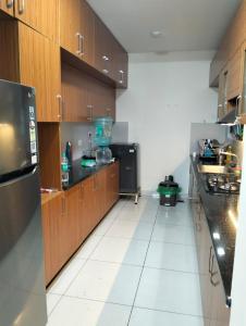 a large kitchen with wooden cabinets and a white tile floor at Elegant Stay at Bangalore International Airport in Bangalore