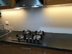a stove top in a kitchen with a counter at Elegant Stay at Bangalore International Airport in Bangalore