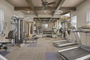 een fitnessruimte met loopbanden en cardio-apparatuur in een kamer bij Landing Stylish 1BD Courtyard Pool in Broken Arrow