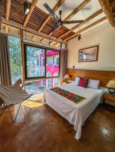 een slaapkamer met een bed, een stoel en een raam bij Los Suspiros Hotel Boutique & Spa in Comala