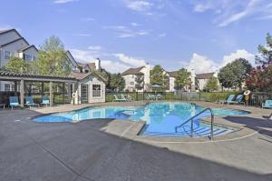 een groot zwembad in een tuin met huizen bij Landing Amazing 2BD in Broken Arrow in Broken Arrow