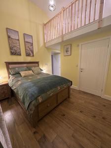 a bedroom with a large bed and a staircase at Y Beudy Bach in Kidwelly