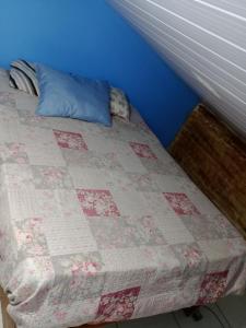 a bed with a quilt on it in a room at Hostel & Cia Itanhaém in Itanhaém