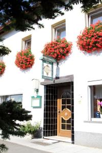 ein weißes Gebäude mit einer Tür mit roten Blumen in der Unterkunft Haus Sonnenschein in Üdersdorf