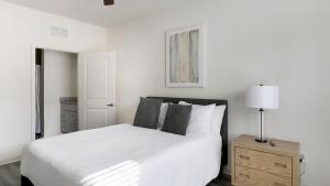 a white bedroom with a white bed and a lamp at Landing Beautiful 1BD in North Fort Worth in Fort Worth +32 photos
