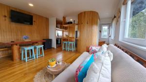 a living room with a couch and a kitchen at Casa Campo Chiloé in Chonchi