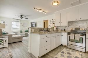a kitchen with white cabinets and a stove top oven at Walk to Shops and Dining Downtown Stuart Home! in Stuart