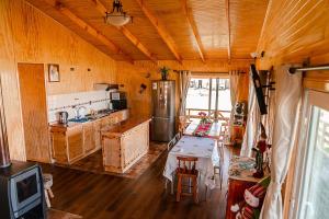 La cuisine est équipée d'une table, d'une cuisinière et d'un réfrigérateur. dans l'établissement Cabañas Altos de Ñida, à Aytuy 10 autres photos