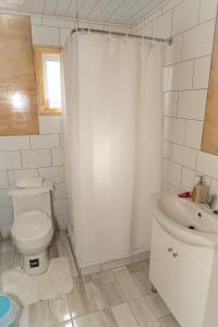 une salle de bains blanche avec toilettes et lavabo dans l'établissement Cabañas Altos de Ñida, à Aytuy