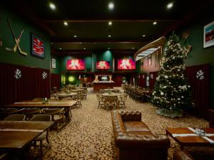 a christmas tree in a restaurant with tables and chairs at Hotel Lac Carling Spa Golf in Harrington