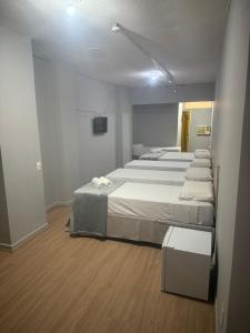 a room with three beds and a tv in it at Unity Hotel - Santos in Santos +31 photos