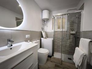 een badkamer met een toilet, een wastafel en een douche bij Looking at the ocean sunset in Puerto de la Madera +26 foto's