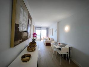 een woonkamer met een tafel en een bank bij Looking at the ocean sunset in Puerto de la Madera