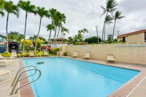 ein Swimmingpool mit Stühlen und Palmen in der Unterkunft Comfy Tropical Condo with Pool - Walk to Beach! in Kahana