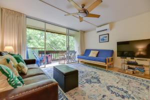 ein Wohnzimmer mit Sofa und Flachbildfernseher in der Unterkunft Comfy Tropical Condo with Pool - Walk to Beach! in Kahana