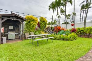 einen Garten mit einem Tisch und Stühlen im Gras in der Unterkunft Comfy Tropical Condo with Pool - Walk to Beach! in Kahana