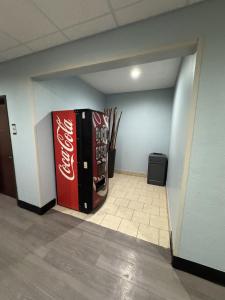 Ein Coca-Cola-Kühlschrank in einem Raum mit Baseballschlägern in der Unterkunft Quality Inn & Suites McAlester on Hwy 69 in McAlester