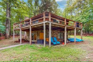 een huis met een veranda rondom in het bos bij Cozy Log Cabin Near Ski Area and Lake including Hot Tub in Swanton