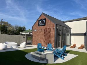 een patio met blauwe stoelen en een gebouw bij Landing at Oslo - Studio in Downtown Hermitage in Hermitage Woods +2 foto's