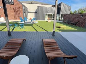 Twee houten banken op een terras met een tuin. bij Landing at Oslo - Studio in Downtown Hermitage in Hermitage Woods