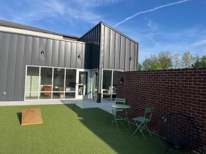 een gebouw met stoelen en een bakstenen muur bij Landing at Oslo - Studio in Downtown Hermitage in Hermitage Woods