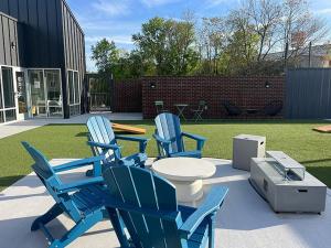 een groep blauwe stoelen, een tafel en een gazon bij Landing at Oslo - Studio in Downtown Hermitage in Hermitage Woods