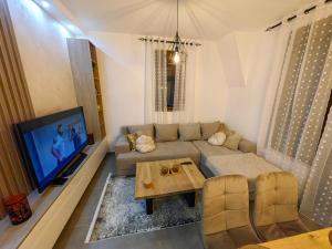 a living room with a couch and a tv at Vidak apartman in Divčibare