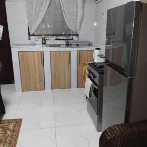 een keuken met een fornuis, een wastafel en een koelkast bij The Retreat in Lusaka